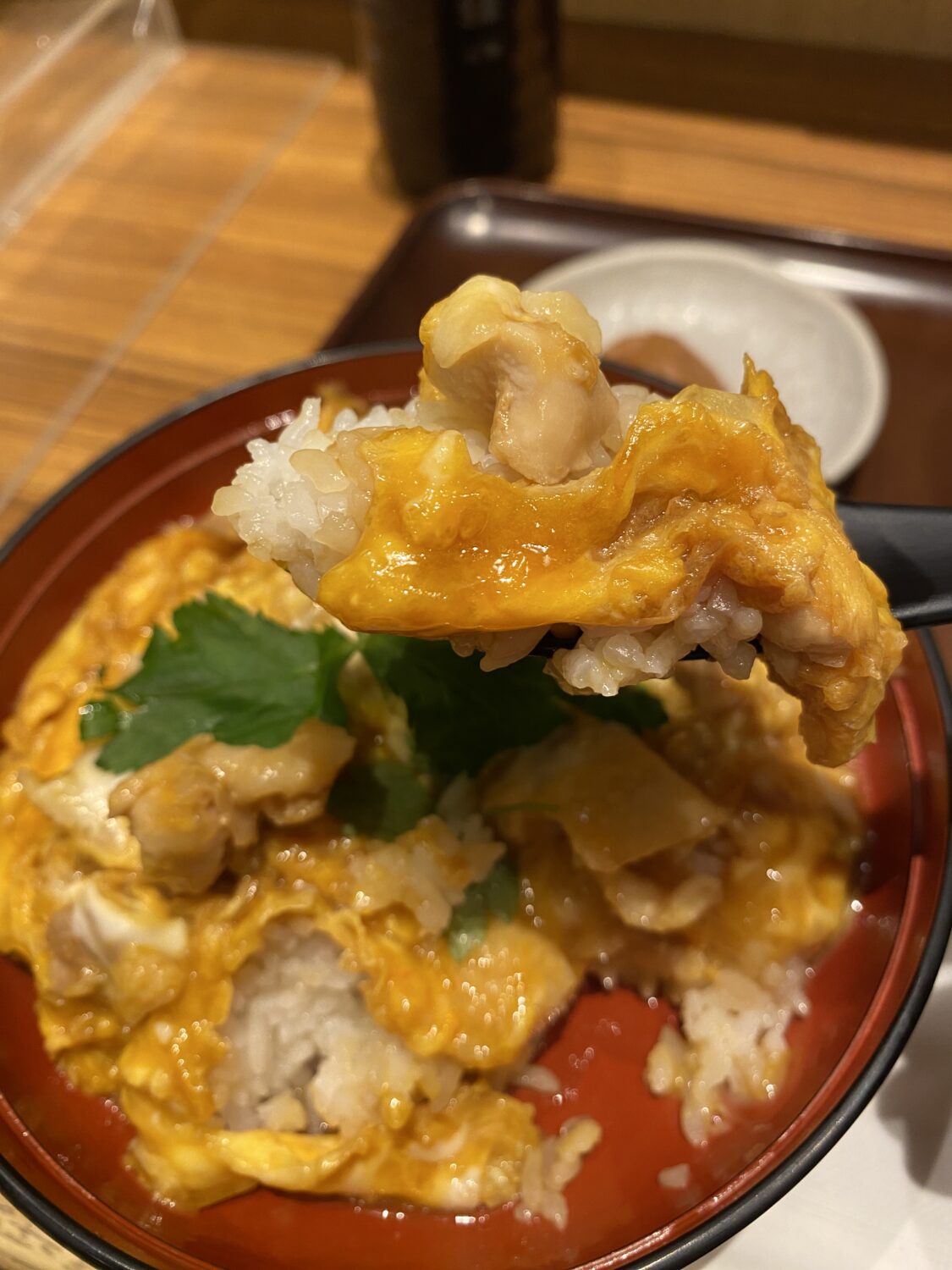 鶏三和の親子丼をレンゲで掬っている写真