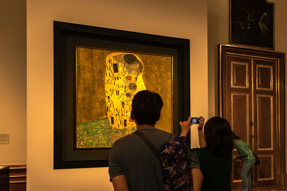ウィーン， オーストリア - 25.08.2022：元のグスタフ・クリムトの絵の近くを見て、写真を作る観光客オーストリアのギャラリーベルヴェデーレでキス