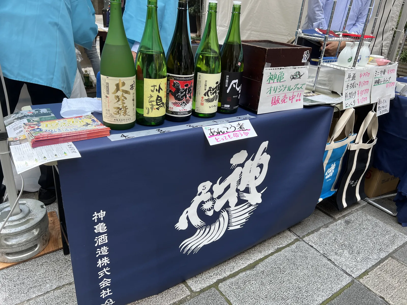 神亀酒造のブースに並ぶ一升瓶とオリジナルグッズ