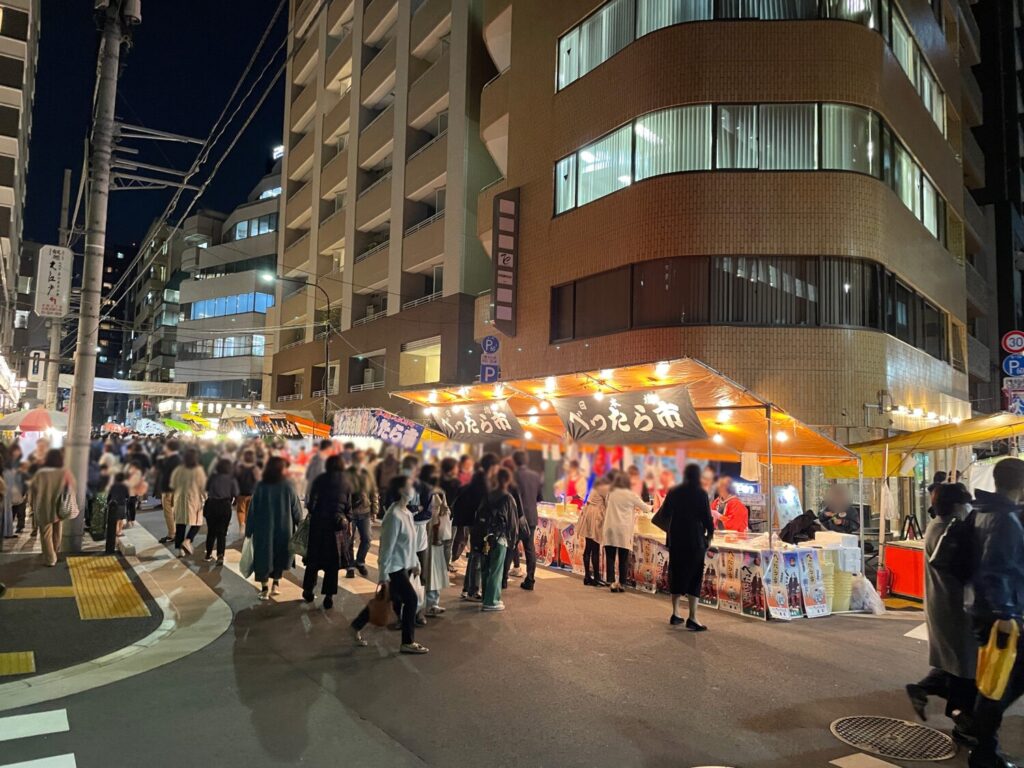 「べったら市」の横幕を掲げた屋台と人でにぎわう夜の日本橋べったら市の会場(2022年)