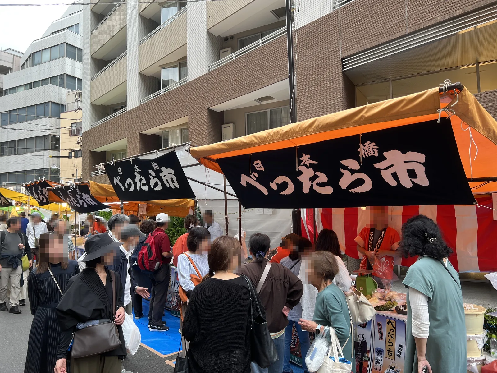 「日本橋べったら市」の幕が続くべったら漬けの露店と来場者