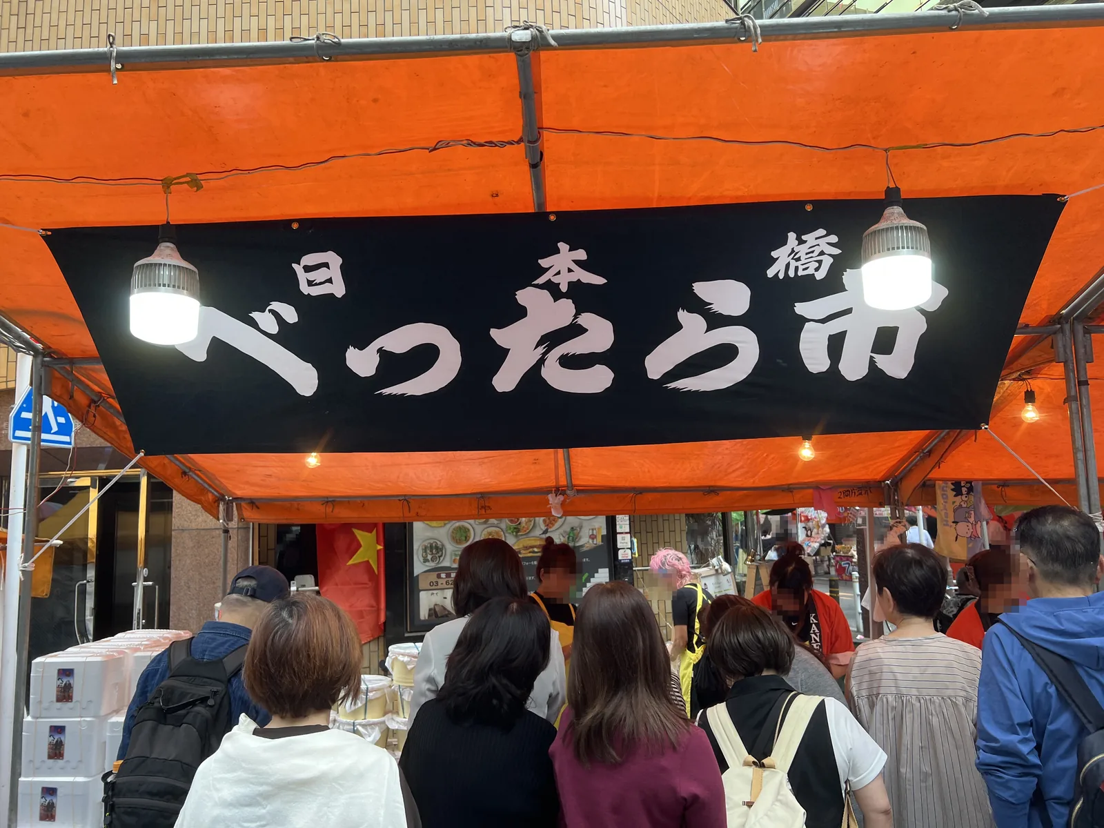 正面から見た金久のべったら漬けの露店と並ぶ来場者