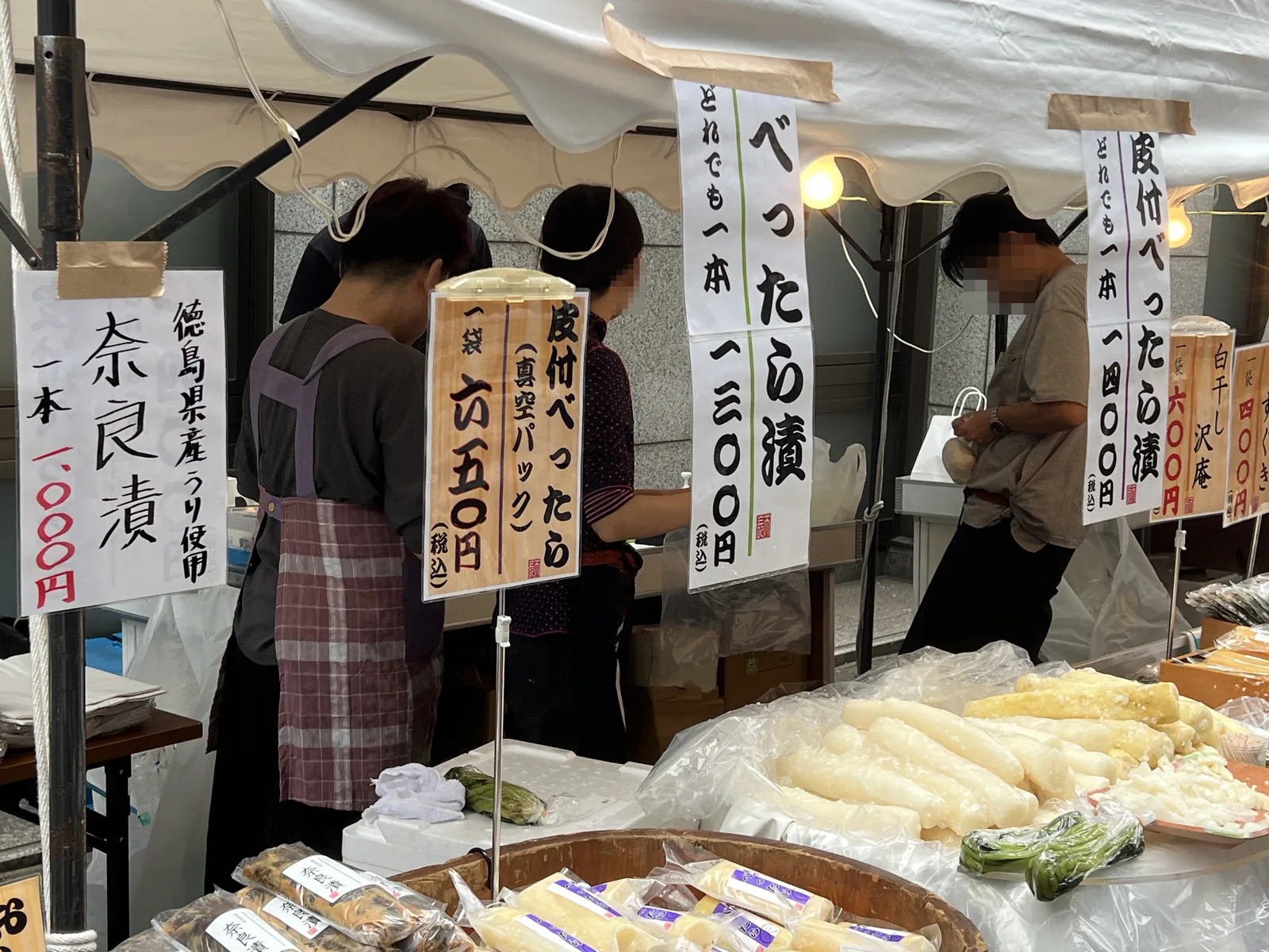 べったら漬や皮付べったら漬、奈良漬の値札が並ぶ漬物の露店
