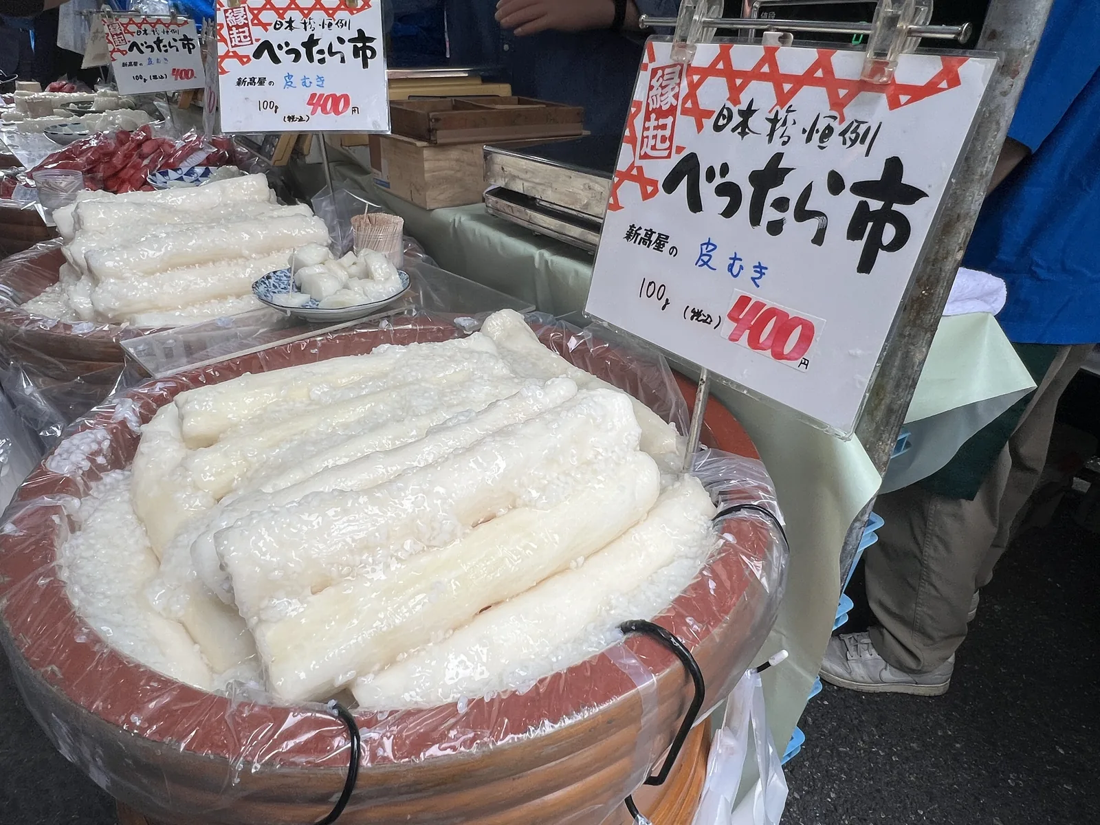 樽に盛られた新高屋の皮むきのべったら漬けと量り売りの値札