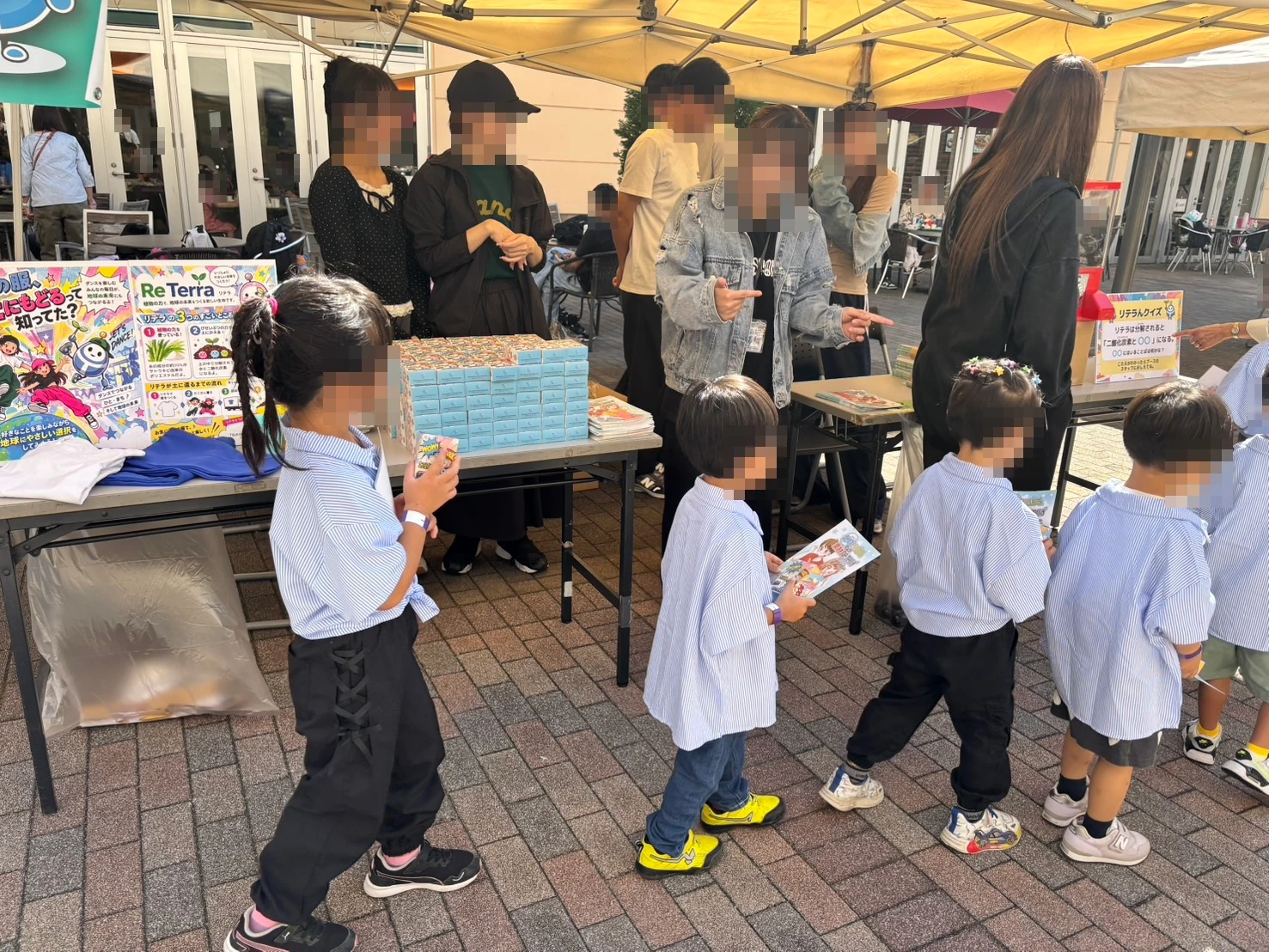 まんがを手にツカモトコーポレーションのブースへやってきたスモック姿の子どもたち