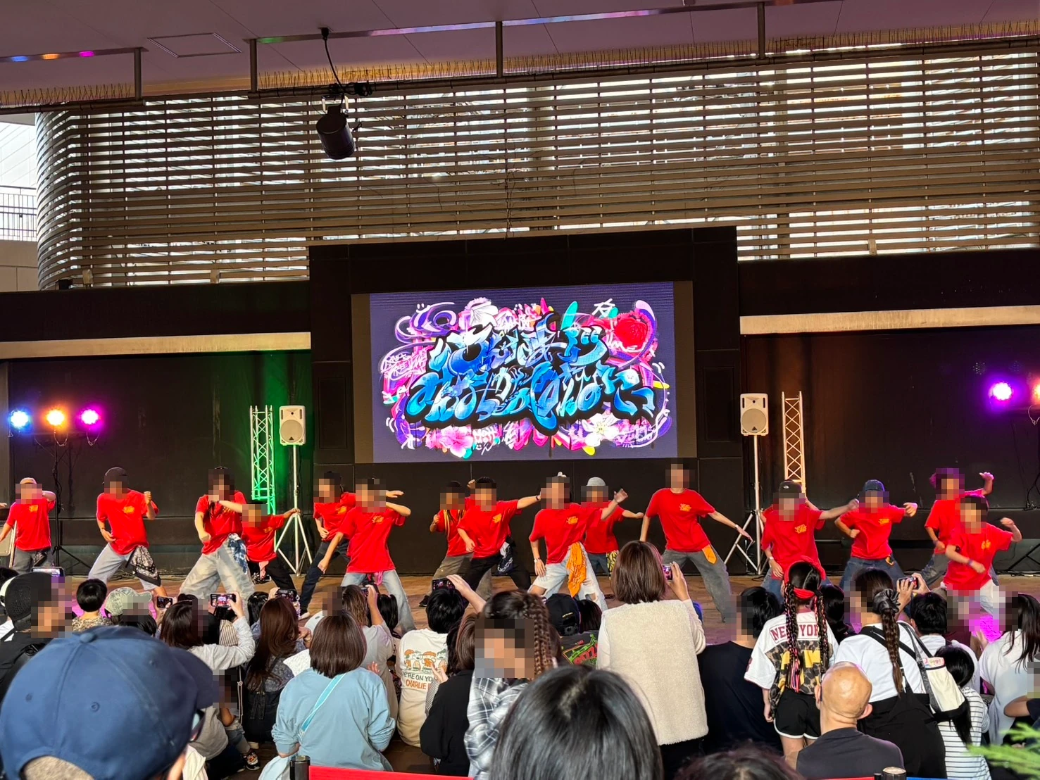 赤いTシャツの大人数のチームのダンスショーケースと観客